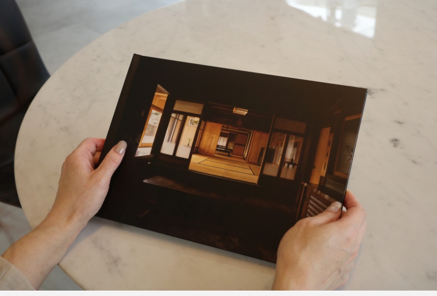 モナミ写真館でアルバムを開きながら写真を見返す様子。写真を“残す”ことの時間が伝わる一枚。