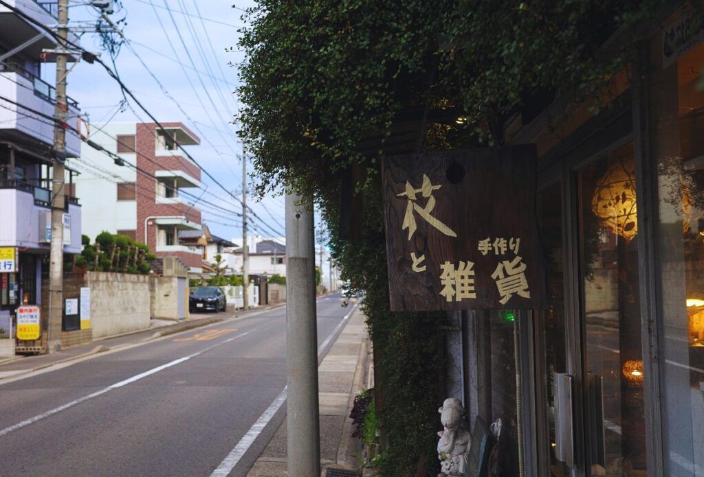 名古屋 千種区 flolla flore の木製看板と街並み。