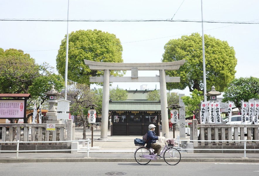 名古屋・大曽根にある山田天満宮前を自転車で走る人。地域の日常風景が残る穏やかな街並み。