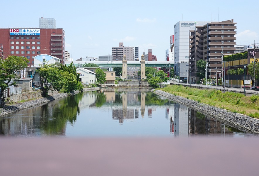 中川運河と松重閘門、名古屋駅方面の街並みが映る水辺の景色