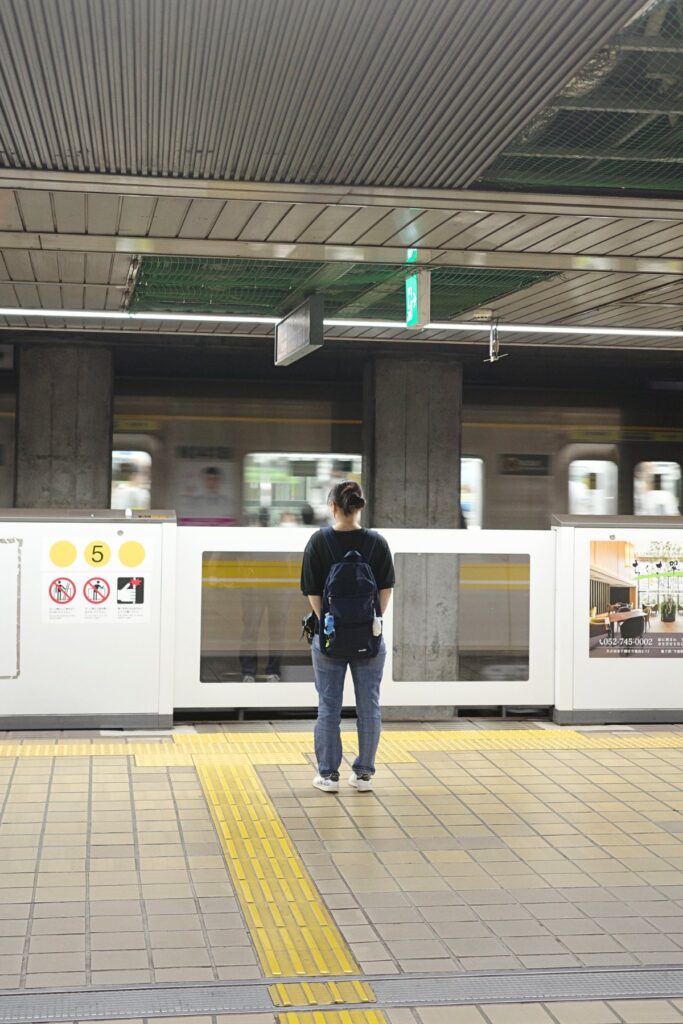 地下鉄ホームで電車を待つ人と流れる車両、名古屋の日常の移動風景